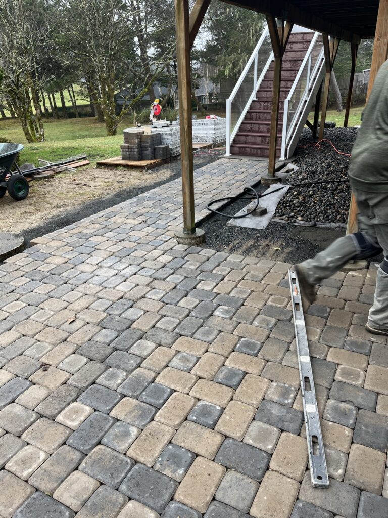 Paver patio being installed beneath an elevated deck. Cannon Beach OR