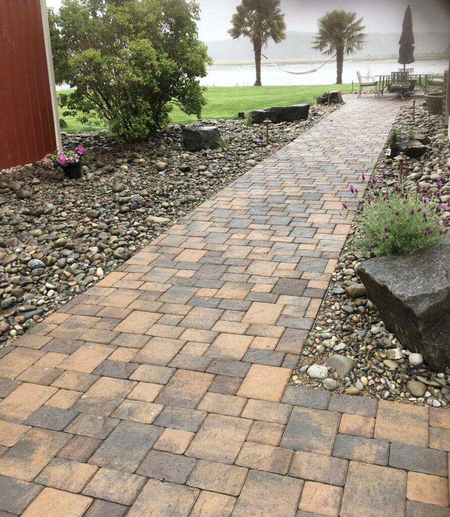 Natural flagstone entry walkway bordered by flowers and landscape plantings.