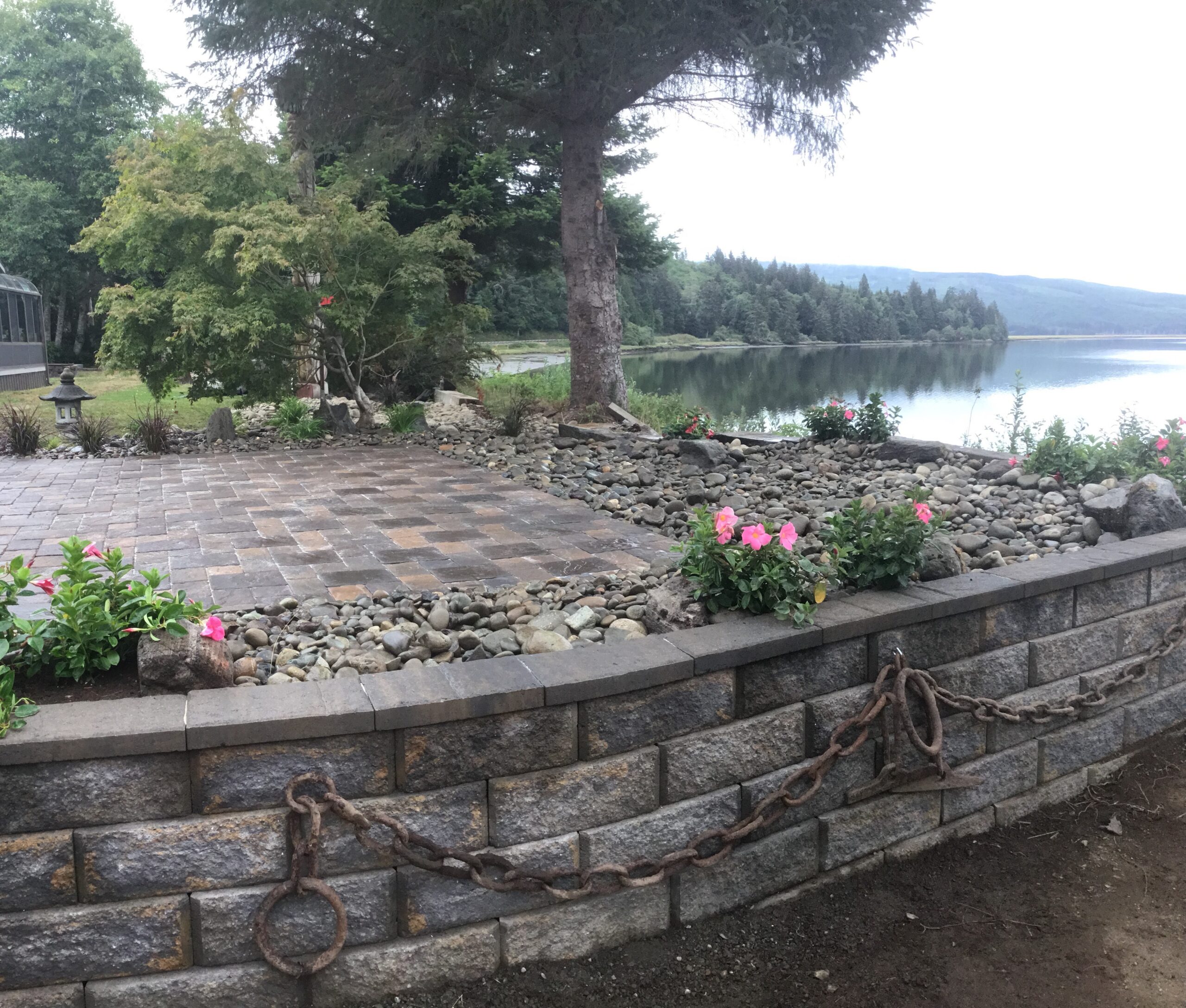 Waterfront block retaining wall with paver patio and landscaping